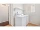 Bright laundry room area including washer, dryer, overhead shelf, and neutral tiled floor at 2791 S Bahama Ct, Aurora, CO 80013