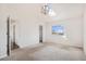 Airy main bedroom featuring vaulted ceiling, skylight, neutral carpet, and large window with neighborhood view at 2791 S Bahama Ct, Aurora, CO 80013