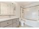 Clean bathroom with white tile, a gray vanity, and a combined tub and shower, offering a serene space at 15475 Andrews Dr # 310, Denver, CO 80239