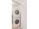 A stacked washer and dryer set sits next to a white louvered door inside a laundry area at 15475 Andrews Dr # 310, Denver, CO 80239