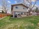 Large backyard with a lush green lawn, a patio, and mature trees for shade at 9667 W Ohio Ave, Lakewood, CO 80226