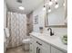 Updated bathroom with a shower, white vanity, framed mirror, and modern fixtures at 9667 W Ohio Ave, Lakewood, CO 80226