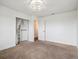 Bright bedroom with brown carpet, ceiling light and a closet with curtains at 9667 W Ohio Ave, Lakewood, CO 80226