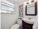 Modern half bathroom with sleek vanity, new fixtures and art accent wall at 9667 W Ohio Ave, Lakewood, CO 80226