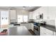 Bright, modern kitchen featuring white cabinets, stainless steel appliances, gray countertops, and a subway tile backsplash at 20801 Randolph Pl, Denver, CO 80249