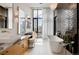 Spa-like bathroom with double vanity, freestanding tub, and dark tile at 1901 Wazee St # 1401, Denver, CO 80202