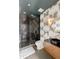 Spa-like bathroom with a walk-in shower, modern vanity, and patterned walls at 1901 Wazee St # 1401, Denver, CO 80202