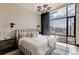 Bright bedroom with a striped headboard and city views at 1901 Wazee St # 1401, Denver, CO 80202