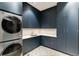 Modern laundry room with front load washer and dryer, cabinetry, and a sink at 1901 Wazee St # 1401, Denver, CO 80202