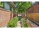 Enclosed backyard garden area with brick wall and gate, offering privacy and a serene outdoor space at 2717 S Steele St, Denver, CO 80210