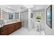 Bathroom featuring double sink vanity, shower with glass door, and bright natural light at 2717 S Steele St, Denver, CO 80210