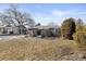 Spacious front yard with a partial brick fence, mature trees and partial snow coverage at 2717 S Steele St, Denver, CO 80210