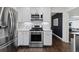 Bright kitchen with stainless steel appliances, white cabinets, and dark hardwood floors at 2717 S Steele St, Denver, CO 80210