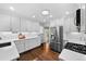 Modern kitchen featuring white cabinets, stainless steel appliances, and hardwood floors at 2717 S Steele St, Denver, CO 80210