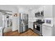Cozy kitchen with stainless steel appliances, white cabinetry, and easy access to adjacent rooms at 2717 S Steele St, Denver, CO 80210