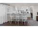 Bright kitchen with white cabinetry, stainless steel appliances, and a breakfast bar with three chairs at 2717 S Steele St, Denver, CO 80210