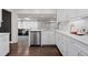 Modern kitchen with stainless steel appliances, quartz countertops, and access to the living room at 2717 S Steele St, Denver, CO 80210