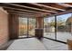 Bright sun room with wood ceiling, brick wall and large windows overlooking backyard at 2717 S Steele St, Denver, CO 80210