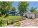 Spacious backyard featuring a lush lawn, a well-kept garden, and a detached garage with vibrant greenery at 2577 Depew St, Edgewater, CO 80214