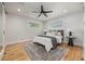 Comfortable bedroom featuring natural light, hardwood floors, ceiling fan and neutral decor at 2577 Depew St, Edgewater, CO 80214
