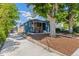 Blue home exterior with landscaped front yard, long driveway, modern porch railing, and mature trees at 2577 Depew St, Edgewater, CO 80214