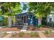 Charming blue home with a landscaped front yard, healthy mature trees, and a welcoming red door at 2577 Depew St, Edgewater, CO 80214