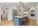 Modern kitchen boasts a large island with seating, stainless steel appliances, and stylish pendant lighting at 2577 Depew St, Edgewater, CO 80214