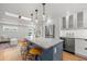 Modern kitchen featuring a large island with seating, stainless steel appliances, and open access to living spaces at 2577 Depew St, Edgewater, CO 80214