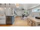 Spacious open-concept living area with a modern kitchen, skylight, and hardwood flooring throughout at 2577 Depew St, Edgewater, CO 80214