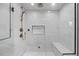Spacious walk-in shower featuring marble tile, dual showerheads, and a built-in bench at 2577 Depew St, Edgewater, CO 80214