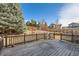 Wooden deck overlooks the backyard featuring mature trees and manicured landscaping at 3938 Lazy K Dr, Castle Rock, CO 80104