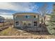 Rear of house shows sliding glass door accessing wooden deck and partially fenced yard at 3938 Lazy K Dr, Castle Rock, CO 80104