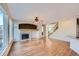 Spacious living room with hardwood floors, stone fireplace, fan and staircase to the second floor at 3938 Lazy K Dr, Castle Rock, CO 80104