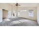 Large main bedroom features a ceiling fan, neutral paint and carpet, and large windows at 3938 Lazy K Dr, Castle Rock, CO 80104