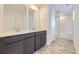 Bathroom featuring double vanity, tile floors, and glass shower at 7307 Waterleaf Trl, Littleton, CO 80125