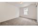 Bright bedroom featuring neutral carpet, a window for natural light, and fresh white walls at 7307 Waterleaf Trl, Littleton, CO 80125