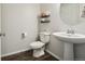 Neat half bathroom featuring a pedestal sink, sleek fixtures, modern decor, and wood-look flooring at 19221 E 65Th Ave, Denver, CO 80249