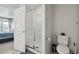 Modern bathroom with glass shower, toilet, and access to the bedroom at 19221 E 65Th Ave, Denver, CO 80249