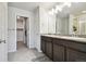 Elegant bathroom with double sinks, granite countertops, and walk-in shower with decorative tile at 19221 E 65Th Ave, Denver, CO 80249