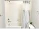 Bright bathroom with a tub and shower combination, and a white tile surround at 19221 E 65Th Ave, Denver, CO 80249