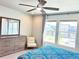 Well-lit bedroom features a dresser with a mirror, a cozy chair, and two windows with neighborhood views at 19221 E 65Th Ave, Denver, CO 80249