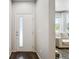 Bright entryway with a door that has a full-length window, next to a view of a sunlit living room at 19221 E 65Th Ave, Denver, CO 80249