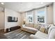 Sunlit living room with a comfortable sofa, contemporary rug, and large windows with stylish curtains at 19221 E 65Th Ave, Denver, CO 80249