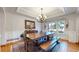 Elegant dining room features a long wooden table, chandelier, and large windows offering natural light at 6414 E Stanford Ave, Cherry Hills Village, CO 80111