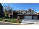 Charming brick two-story home with a tile roof, manicured lawn, and three-car garage at 6414 E Stanford Ave, Cherry Hills Village, CO 80111