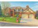Charming two-story brick home with arched entryway, two-car garage, and landscaped front yard at 6414 E Stanford Ave, Cherry Hills Village, CO 80111