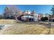 Expansive backyard with a well-maintained lawn and a charming two-story home with a spacious deck at 6414 E Stanford Ave, Cherry Hills Village, CO 80111