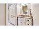Well-lit bathroom featuring a granite countertop and a custom-built linen closet for ample storage at 6414 E Stanford Ave, Cherry Hills Village, CO 80111