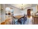 Formal dining room showcasing a wooden table set for six, with views into the living room and kitchen at 6414 E Stanford Ave, Cherry Hills Village, CO 80111