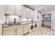 Laundry room features white cabinets, granite counters, stainless steel sink, and a front-loading washer and dryer at 6414 E Stanford Ave, Cherry Hills Village, CO 80111